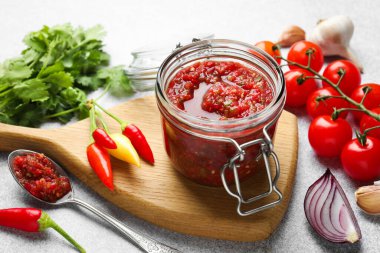 Kavanozda salsa sosu ve ışık masasında malzemeler, yakın plan.