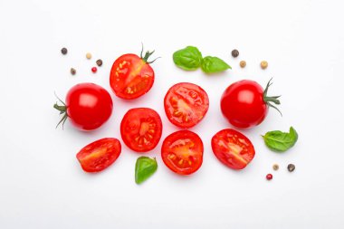Taze olgun domatesler, fesleğenler ve beyaz arka planda biberler.
