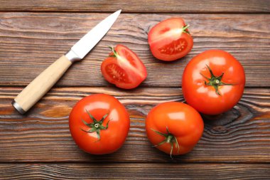 Taze olgun domatesler ve bıçak tahta masanın üstünde, düz yatıyordu.