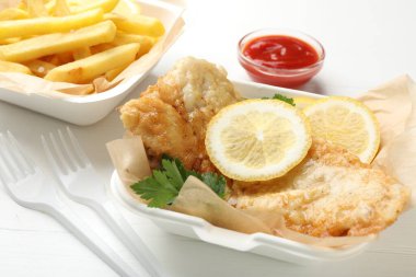 İngiliz Geleneksel Balık ve patates kızartması beyaz ahşap masada servis edilir.