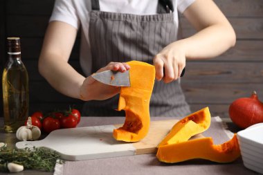 Masada taze balkabağı kesen kadın, yakın plan.