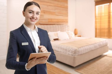 Odada tablet bilgisayarı olan bir otel yöneticisi.