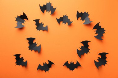 Cadılar Bayramı dekoru. Turuncu arka planda siyah kağıt yarasalardan yapılmış çerçeve düz yatıyordu. Metin için boşluk
