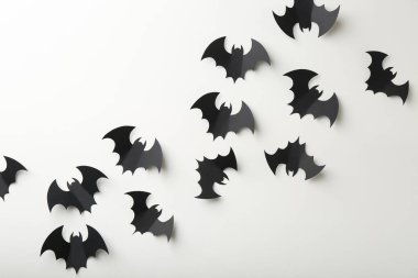 Cadılar Bayramı dekoru. Beyaz zemin üzerinde siyah kağıt yarasalar, düz yatıyordu