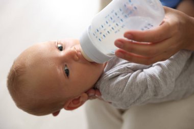 Anne bebeğini biberonla besliyor.