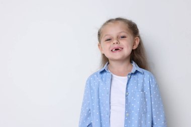 Açık gri arka planda gülümseyen küçük bir kız. Metin için boşluk