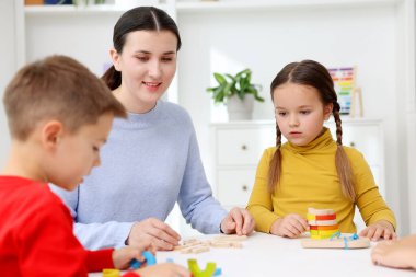 İlkokulda beyaz masadaki sevimli çocuklar ve öğretmenler.