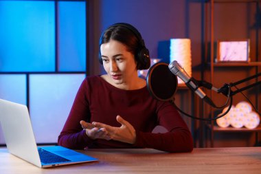 Podcast sunucusu stüdyoda talk show kaydediyor.