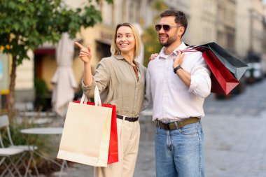 Farklı alışveriş çantaları olan mutlu bir çift.