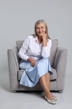 Açık gri arka planda koltukta profesyonel psikoterapist