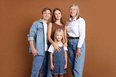 Kahverengi arka planda oğlu ve ailesi olan yaşlı bir kadının portresi.