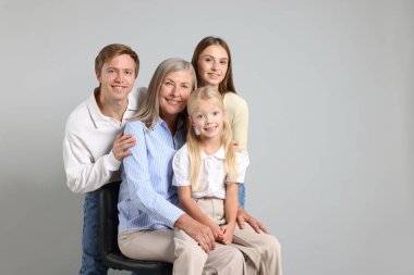 Aydınlık bir arkaplanda son sınıf öğrencisi ve ailesinin portresi. Metin için boşluk