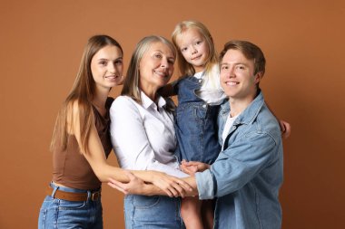 Kahverengi arka planda oğlu ve ailesi olan yaşlı bir kadının portresi.