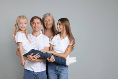 Açık gri arka planda, oğlu ve ailesiyle birlikte son sınıf öğrencisi bir kadının portresi. Metin için boşluk