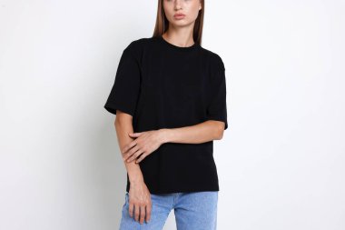 Beyaz arka planda siyah tişört giyen kadın, yakın plan. Tasarım için model