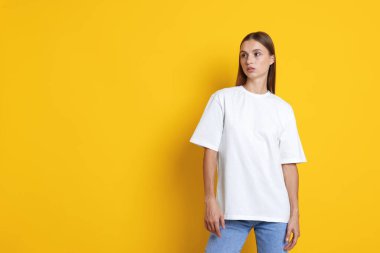 Turuncu arka planda beyaz tişört giyen bir kadın. Tasarım için model