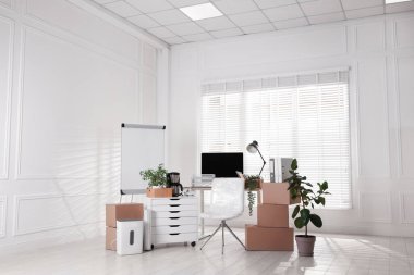 Taşınma günü. Mukavva kutular, bilgisayar ve mobilyalar ofiste.