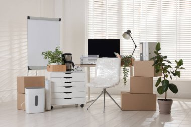 Taşınma günü. Mukavva kutular, bilgisayar ve mobilyalar ofiste.