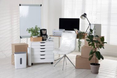 Taşınma günü. Mukavva kutular, bilgisayar ve mobilyalar ofiste.