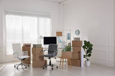 Taşınma günü. Mukavva kutular, bilgisayar ve mobilyalar ofiste.
