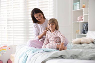 Anne evde kızının saçını tarıyor.