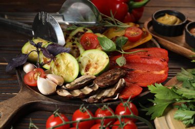 Vejetaryen barbeküsü. Ahşap masada servis edilen lezzetli ızgara sebzeler, yakın plan.