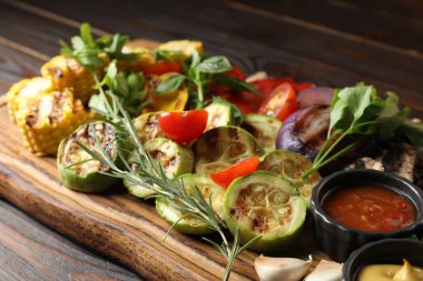 Vejetaryen barbeküsü. Ahşap masada servis edilen lezzetli ızgara sebzeler, yakın plan.