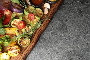 Vejetaryen barbeküsü. Gri masada servis edilen lezzetli ızgara sebzeler, üst manzara. Metin için boşluk