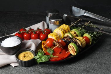 Vejetaryen barbeküsü. Gri masada servis edilen lezzetli ızgara sebzeler.