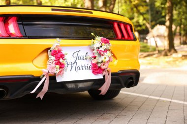 Düğün arabası. Cabriolet dekore edilmiş. Sadece evlilik kartı ve açık havada güzel çiçekler, yakın plan.