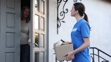 Yaşlılar için insani yardım. Gönüllü olarak dışarıda kalan yaşlı kadınlara yiyecek ve karton kutular veriyor.