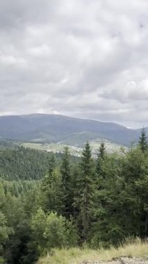 Bulutlu gökyüzünün altındaki güzel dağların resimli görüntüsü. Kamera sola hareket ediyor
