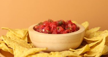 Nacho 'yu nefis bir salsa sosuna batıran kadın, yakın plan.