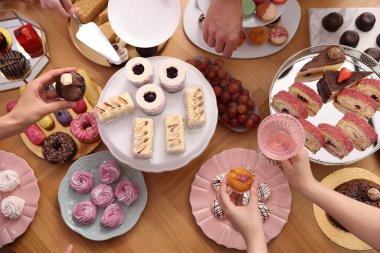 İnsanlar açık büfeden farklı tatlılar ve içecekler alıyor.