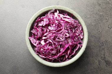 Gri masadaki kasede parçalanmış kırmızı lahana, üst manzara.