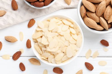 Taze badem gevrekleri ve beyaz ahşap masada fındıklar.