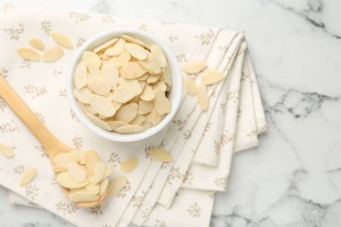 Beyaz mermer masada taze badem taneleri, üst manzara. Metin için boşluk