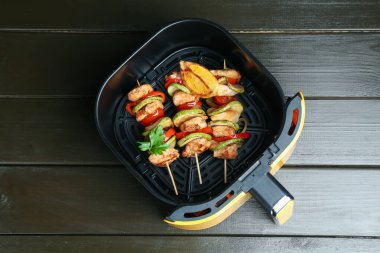 Tavuklu şişler ve sebzeler ahşap masada, tavuklu kızartma sepetinde.