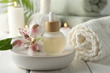 Güzel bir spa kompozisyonu, temel yağ ve yanan mumlar beyaz ahşap masada, yakın plan.