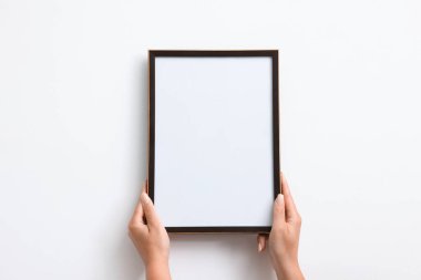 Beyaz duvara boş bir diploma çerçevesi asan kadın, yakın plan. Tasarım için model