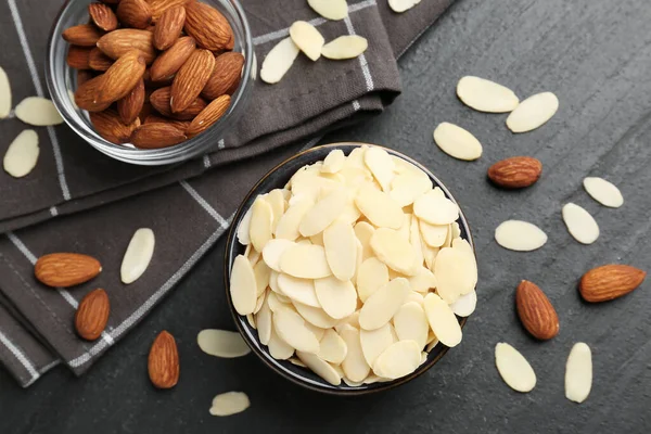 Taze badem gevrekleri kasede ve fındıklar gri masada, düz yatıyordu.