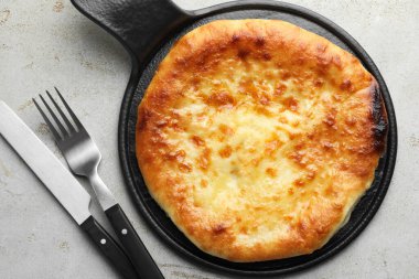 Delicious Megrelian khachapuri served on grey table, top view