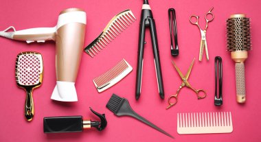 Different hair styling tools on pink background, flat lay