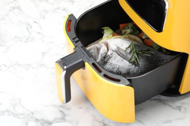 Çiğ balık, limon ve sebzeler, tavada, beyaz mermer masada, yakın plan. Metin için boşluk