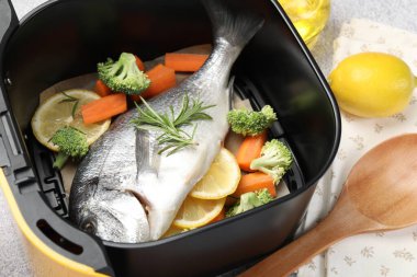 Çiğ balık, limon ve sebzeler açık gri masada, yakın plan.