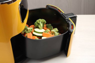 Çiğ havuç, brokoli ve kabak tavada, beyaz ahşap masada, yakın plan.