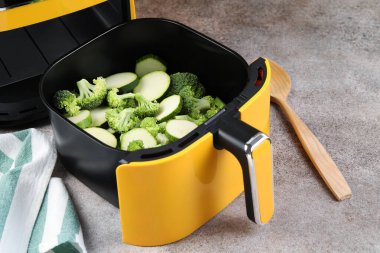 Çiğ brokoli ve kabağı gri masadaki kızartma makinesinde kes.