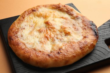 Soluk turuncu arka planda nefis bir Megrelian Khachapuri, yakın plan.