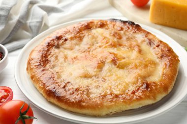 Lezzetli Megrelian Khachapuri ve beyaz ahşap masa üzerindeki ürünler.