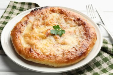 Lezzetli Megrelian Khachapuri beyaz ahşap masada servis yapıyor, yakın plan.